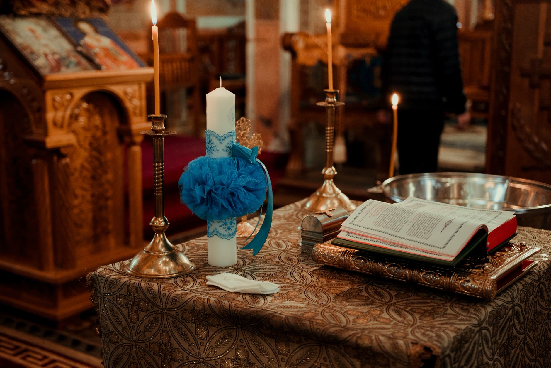 Altar con vela y moño azul para el bautizo